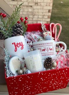 a red box filled with christmas items and candy canes on top of a window sill