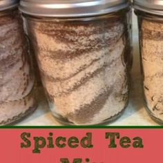 four jars filled with spices sitting on top of a white counter next to the words spiced tea mix