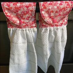 two white and red towels hanging on a clothes line