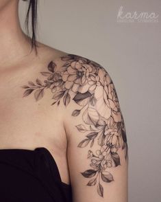 a woman wearing a black dress with flowers on her shoulder and chest tattoo design by karmna