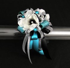 a bridal bouquet with white flowers and blue ribbon on a silver barbwire