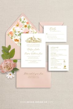 the wedding stationery is shown with pink flowers and greenery on top of it