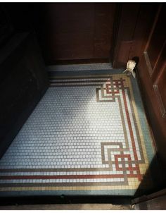 the bathroom floor is made up of white and brown tiles with an intricate design on it