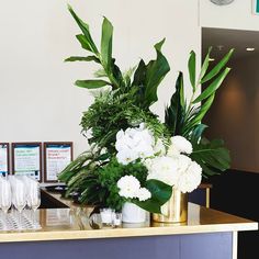 flowers and greenery are displayed on the counter