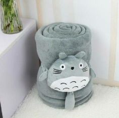 a gray totoro towel sitting on top of a white rug