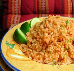 a yellow plate topped with rice and cucumber next to a lime wedged slice