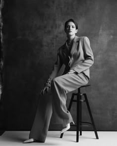 a woman sitting on top of a stool