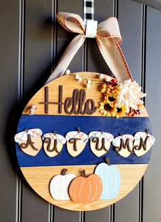 a wooden sign that says hello autumn hanging on a door