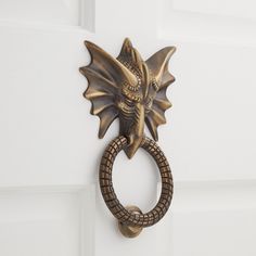 a door handle with a dragon head on it's side and a snake ring in the middle