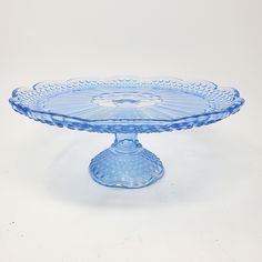 a blue glass cake plate sitting on top of a table