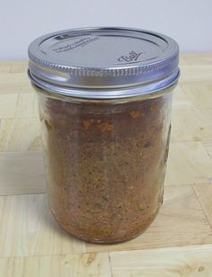 a glass jar filled with food sitting on top of a wooden table