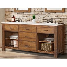 a bathroom vanity with two sinks and wooden cabinetry in front of a brick wall