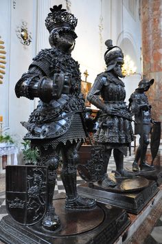 two statues of knights are on display in a church