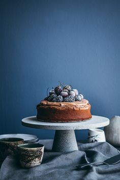 a cake sitting on top of a table next to bowls of fruit and silverware