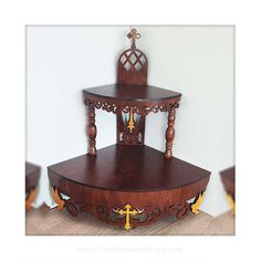 a wooden table with two tiered shelves on each side and a cross at the top