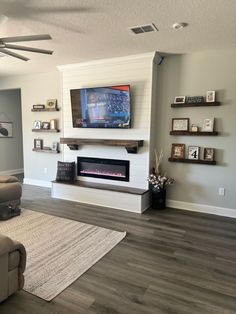 a living room with a couch, fireplace and tv on the wall in it's corner