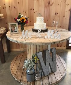 a wooden table topped with a cake and two vases