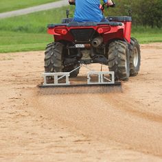 a man riding on the back of a red four wheeler