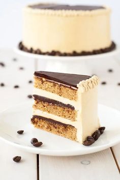 a piece of cake on a plate with chocolate chips around it and the rest of the cake in the background