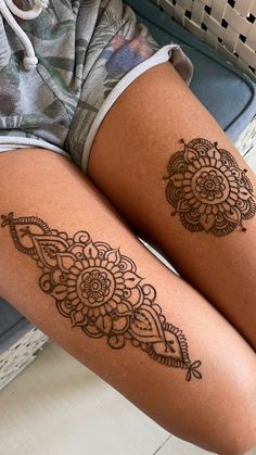 two women with tattoos on their legs sitting next to each other