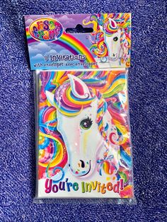 a package with a unicorn face and rainbow hair on it's head, in front of a blue background