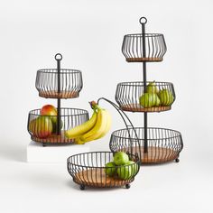 three metal baskets with fruit in them