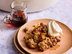 a plate with some food on it next to a cup of tea and a pot