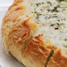 a close up of a bread with cheese and spinach in it on a plate