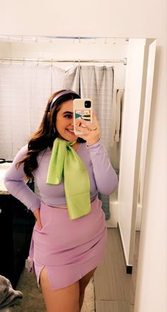 a woman is taking a selfie in the mirror wearing a purple dress and green scarf