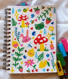 an open notebook with colorful stickers on it next to crayons and markers