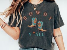 Howdy y'all! This is a Comfort Colors Shirt with a western, country vibe. Cowgirls are the cutest! Comfort Colors introduces its garment-dyed t-shirt; a fully customizable tee made 100% with ring-spun cotton. The soft-washed, garment-dyed fabric brings extra coziness to your wardrobe while the relaxed fit makes it an excellent daily choice. The double-needle stitching throughout the tee makes it highly durable while the lack of side-seams helps the shirt retain its tubular shape. .: 100% ring-spun cotton .: Medium fabric (6.1 oz/yd² (206.8 g/m .: Relaxed fit .: Sewn-in twill label Summer Graphic Print Tops For Country Events, Graphic Print Tops For Summer Country Events, Graphic Print Tops For Country Events In Summer, Pre-shrunk Tops For Rodeo In Fall, Western Style T-shirt For Country Concerts In Spring, Country Style T-shirt For Rodeo In Spring, Vintage Tops For Fall Country Concerts, Trendy Tops For Country Concerts, Retro Fall Rodeo T-shirt