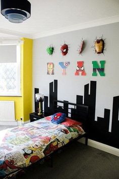 a bedroom with yellow walls and black headboard, spiderman bedspread, and other decorations on the wall