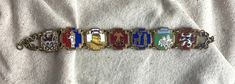 "You will receive this superb antique enamel Belgian souvenir bracelet. It measures 7 1/2\" x 3/4\" and is cast in an antiqued bronze tone base metal. The enamel on each panel is bright and intact. There are seven panels, Dinant, La Roche, Spa, Saint Hubert, Bastogne, Bruxelles, and Bouillon. This piece cam out of Belgium from my favorite antique store. It is in very good vintage condition with minimal signs of wear to the front and only slight ,metal loss on the back. Gorgeous. For finished vin Antique Enamel Bracelet Collectible, Antique Brass Collectible Bracelets, Vintage Beads Necklace, Antique Store, Enamel Bracelet, Rhinestone Bracelet, Antique Stores, Chain Link Bracelet, Base Metal