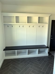 an empty room with white cabinets and black bench