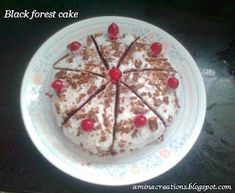 a white plate topped with a cake covered in frosting and cherries on top of it