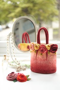 a handbag sitting on top of a table next to a mirror and flower decoration