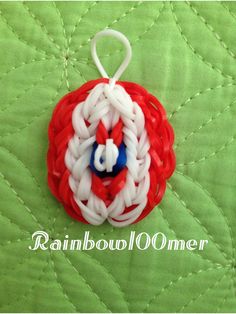 an ornament made out of red, white and blue yarn on a green quilt