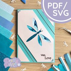 a card with blue and white paper on it, surrounded by other crafting supplies