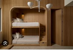 a bunk bed in a room with wooden paneling and white pillows on the bottom bunk