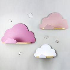 two pink and white cloud shaped shelves against a gray wall with stars in the background