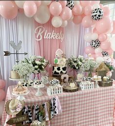 a table topped with lots of pink and white balloons next to a checkered table cloth