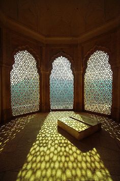 an intricately designed room with sunlight streaming through the windows and casting shadows on the walls