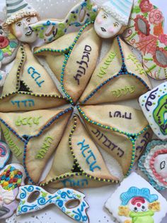 decorated cookies arranged in the shape of an eight pointed star with hebrew writing on them