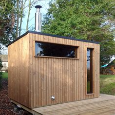 a small wooden building with a window on the outside and wood flooring around it