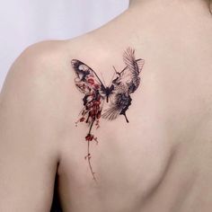 a woman's back with a butterfly tattoo on it