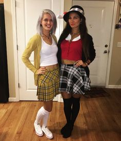 two women dressed up in costumes standing next to each other on a hard wood floor