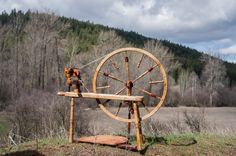 an old spinning wheel sits in the middle of a field