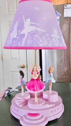 a lamp that is sitting on top of a table with figurines around it