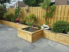 an outdoor garden with wooden planters filled with flowers