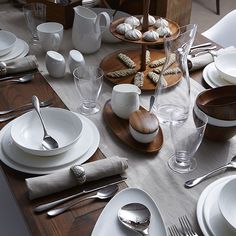 the table is set with white dishes and silverware